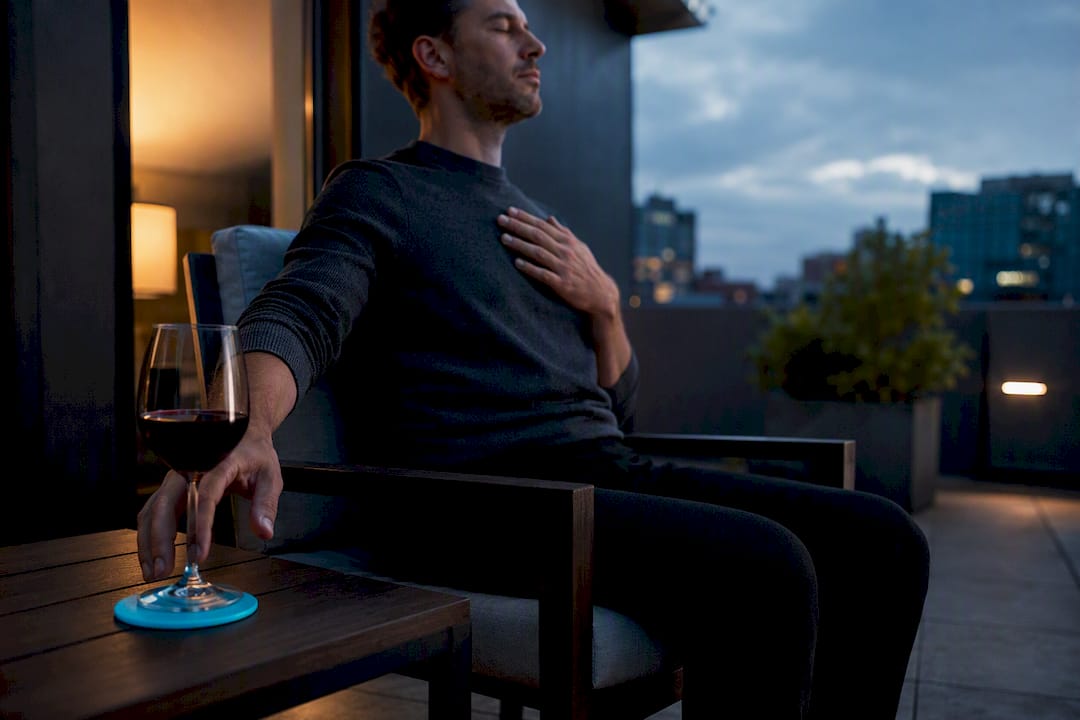 Person practising breathing beside untouched wine glass